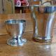 Silver-plated cup and egg cup set with floral decoration.