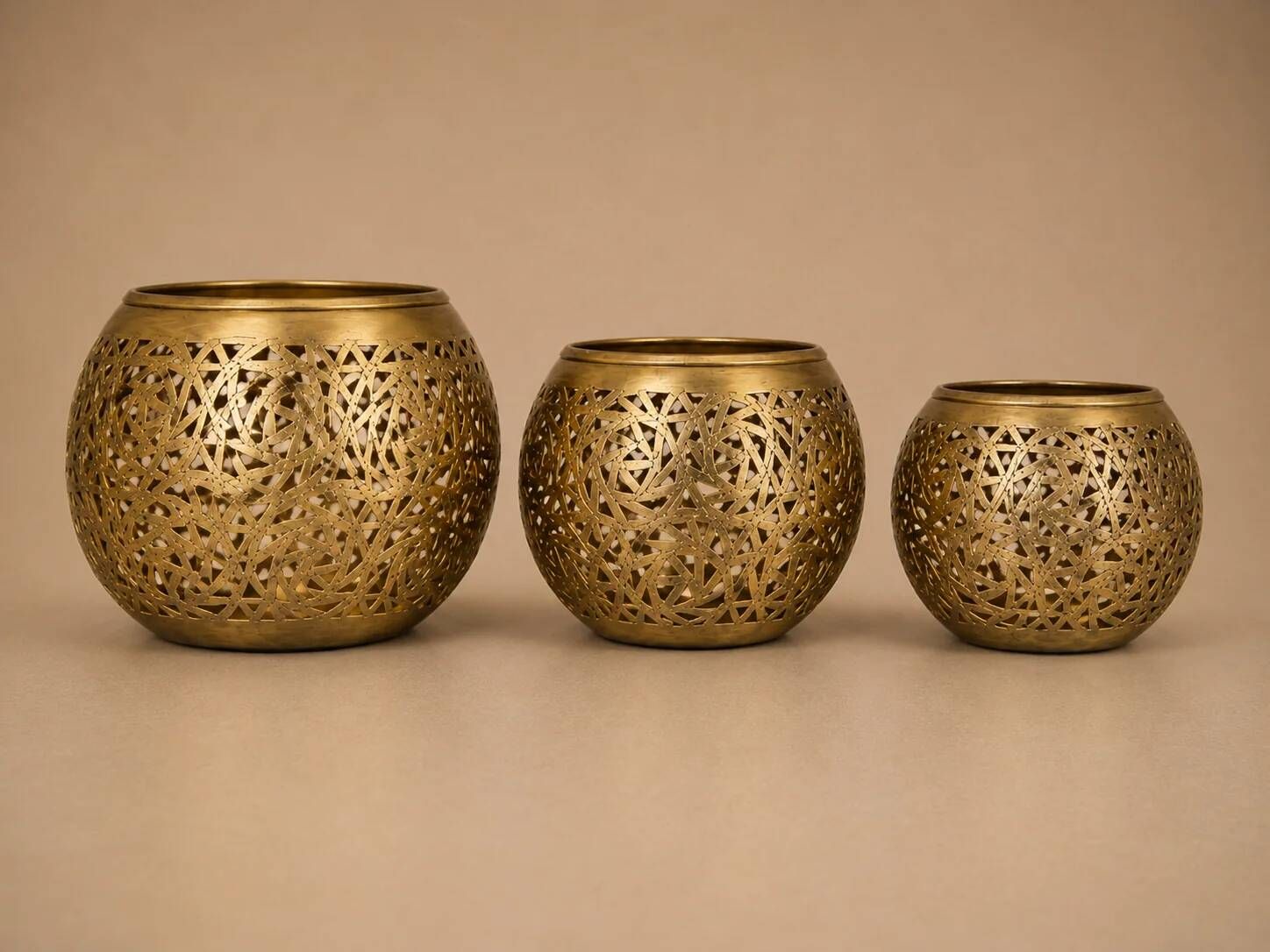 Set of 3 handmade brass candle holders with an openwork pattern.
