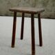 Old wooden stool with log feet