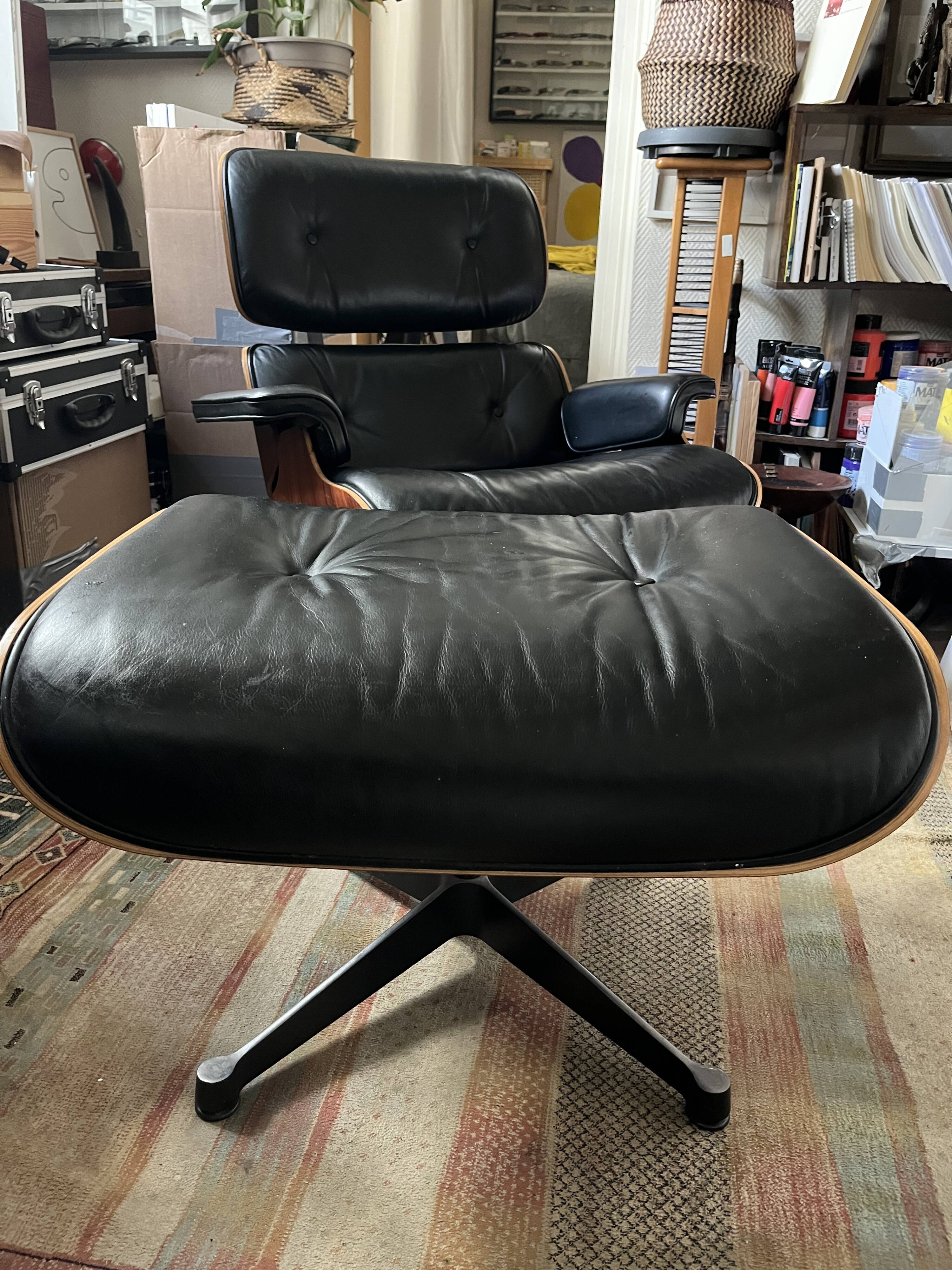 Black leather Eames Vitra armchair, original with rosewood ottoman.