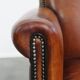 Sheepskin leather armchair in a cognac color with black piping
