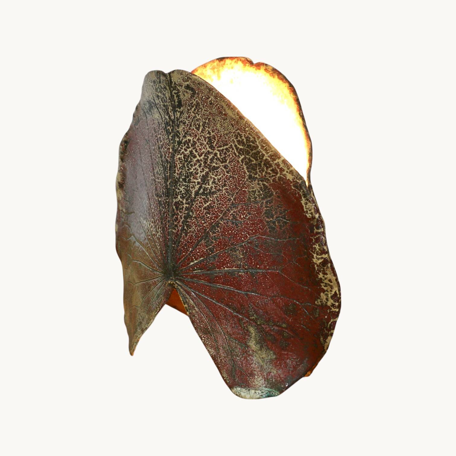 A ceramic lamp in the shape of a leaf.