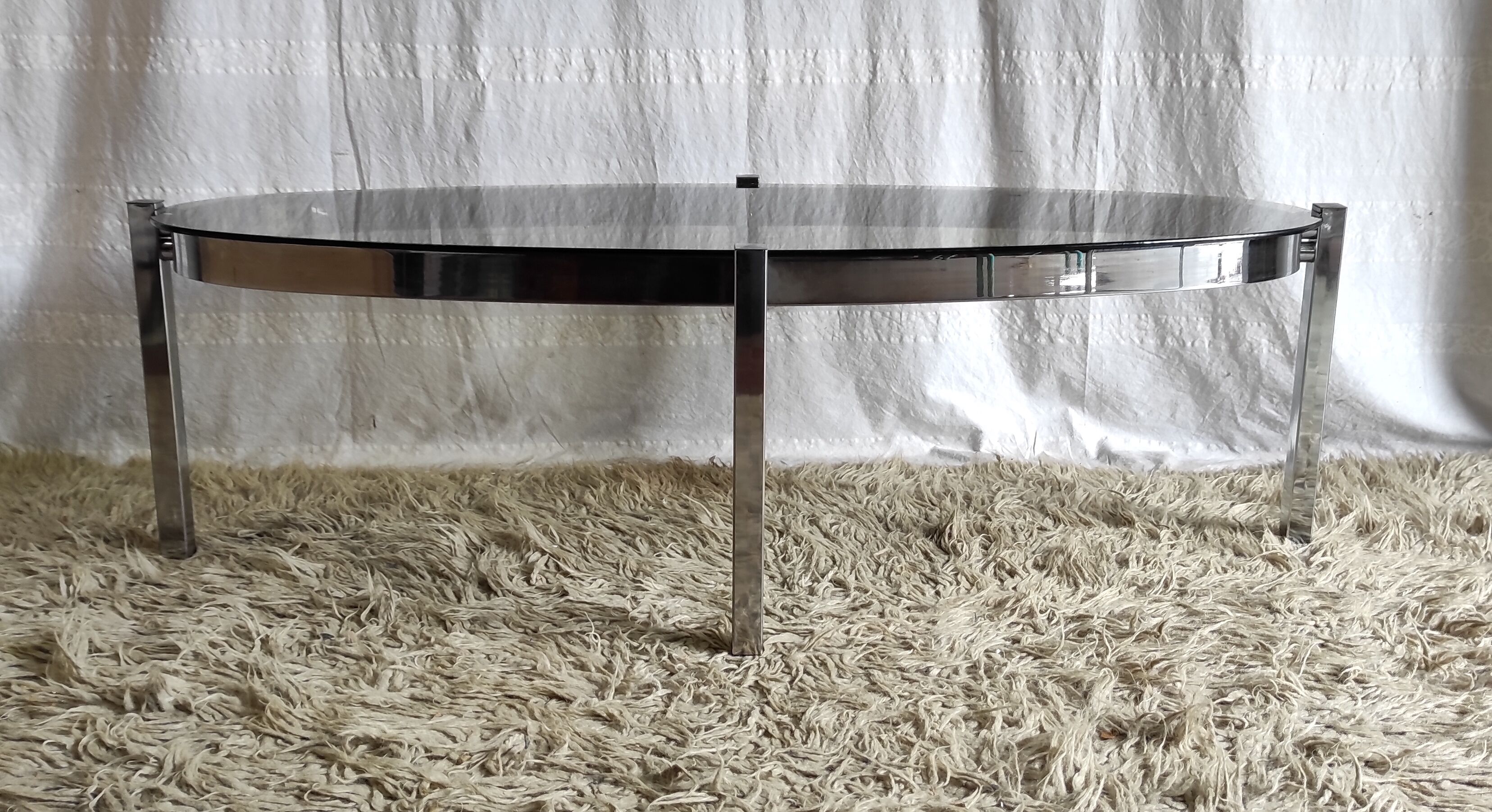 Table basse de forme élyptique en metal chomé et verre fumé, années 70