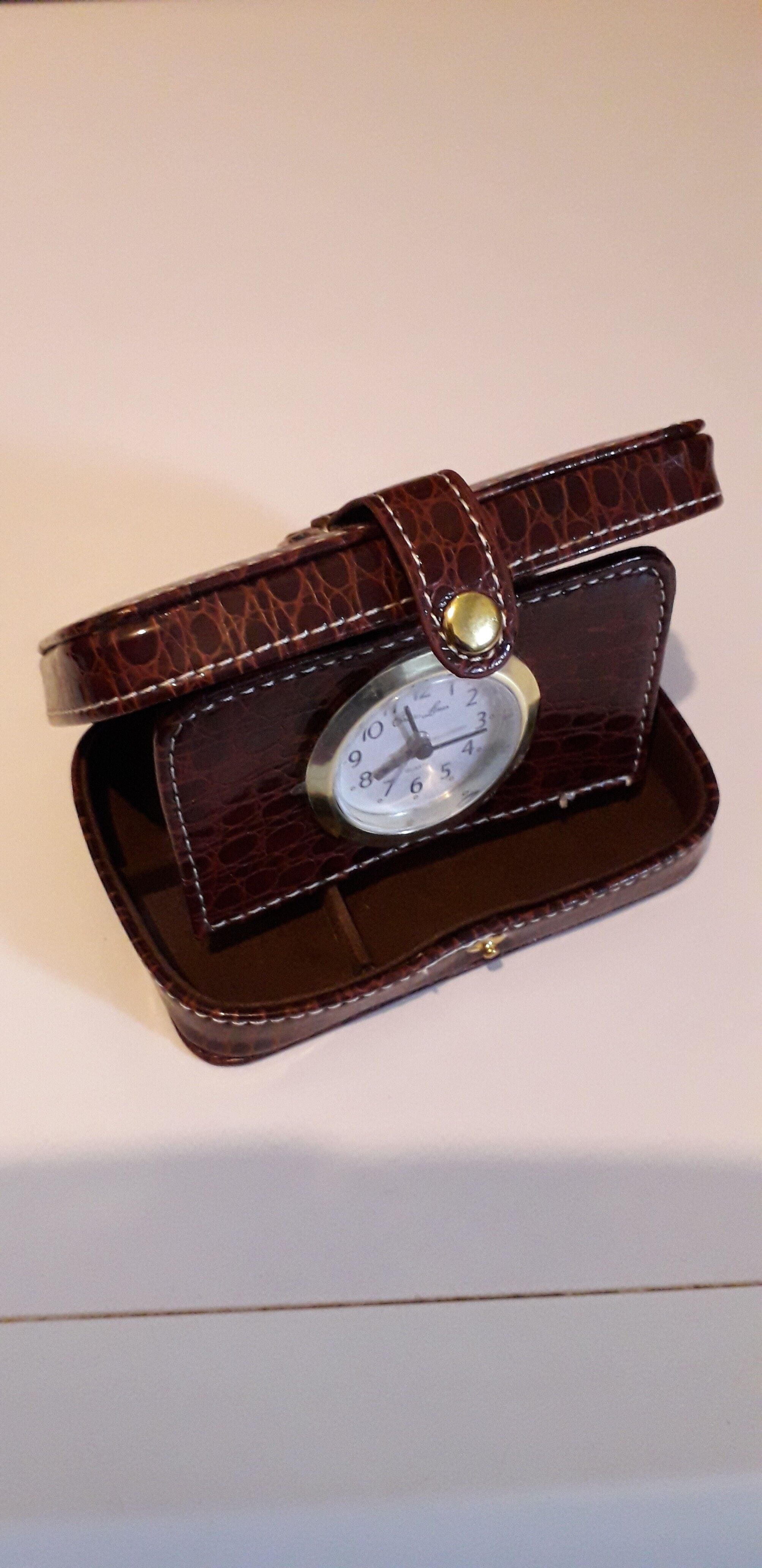 Small travel alarm clock in its case with jewelry compartments