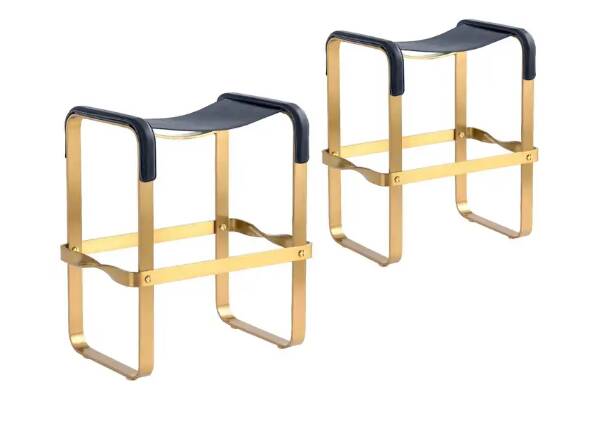 A pair of blue wanderlust stools without a backrest with brass.