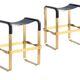 A pair of blue wanderlust stools without a backrest with brass.