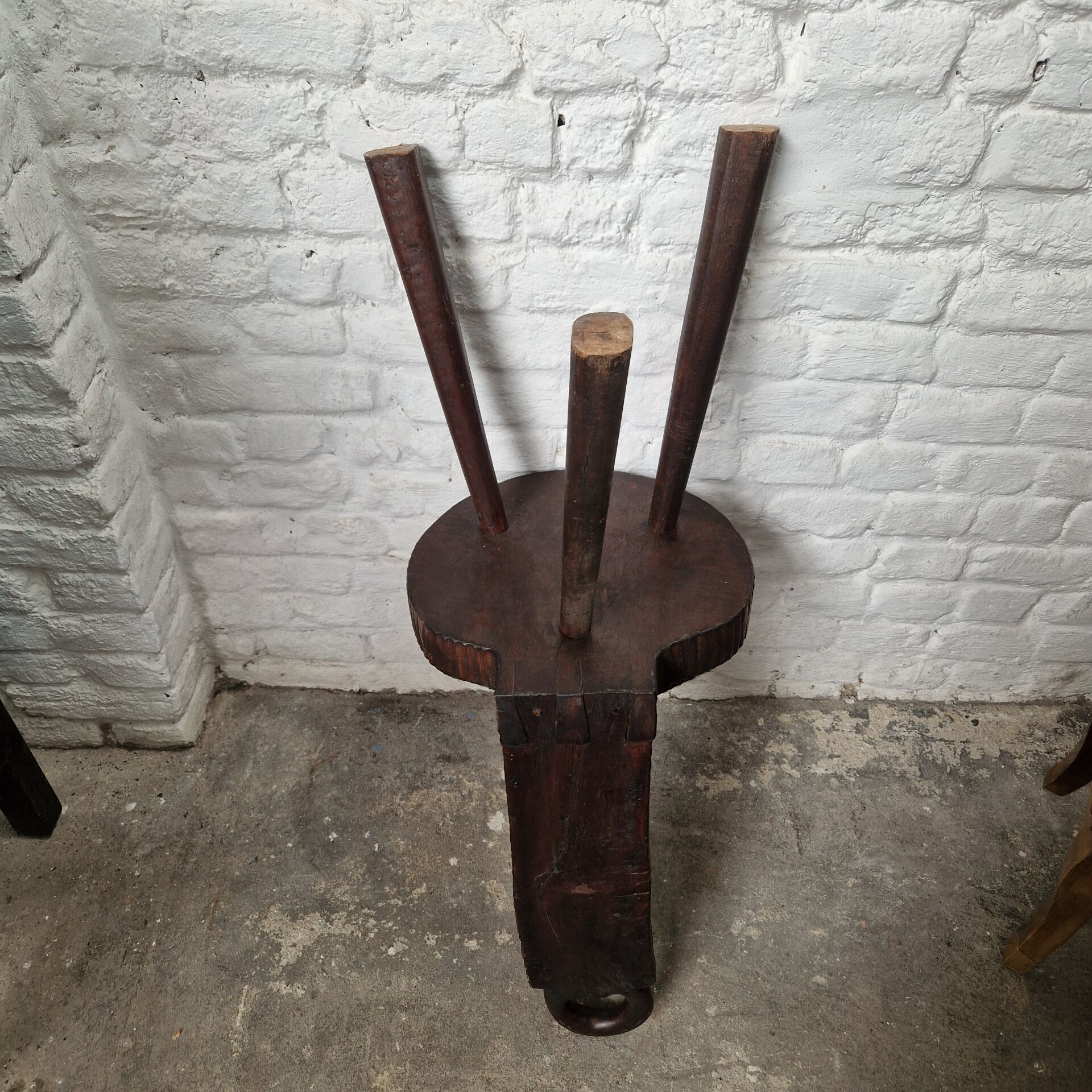 Antique tripod chair in solid wood and animal skin.