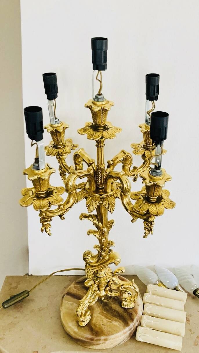 Massive gilded bronze chandeliers from the mid-20th century with marble bases.