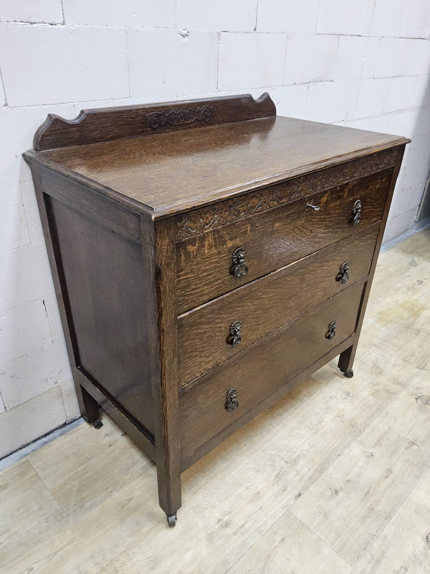 Antique chest of drawers on wheels with wood carving (key top drawer)