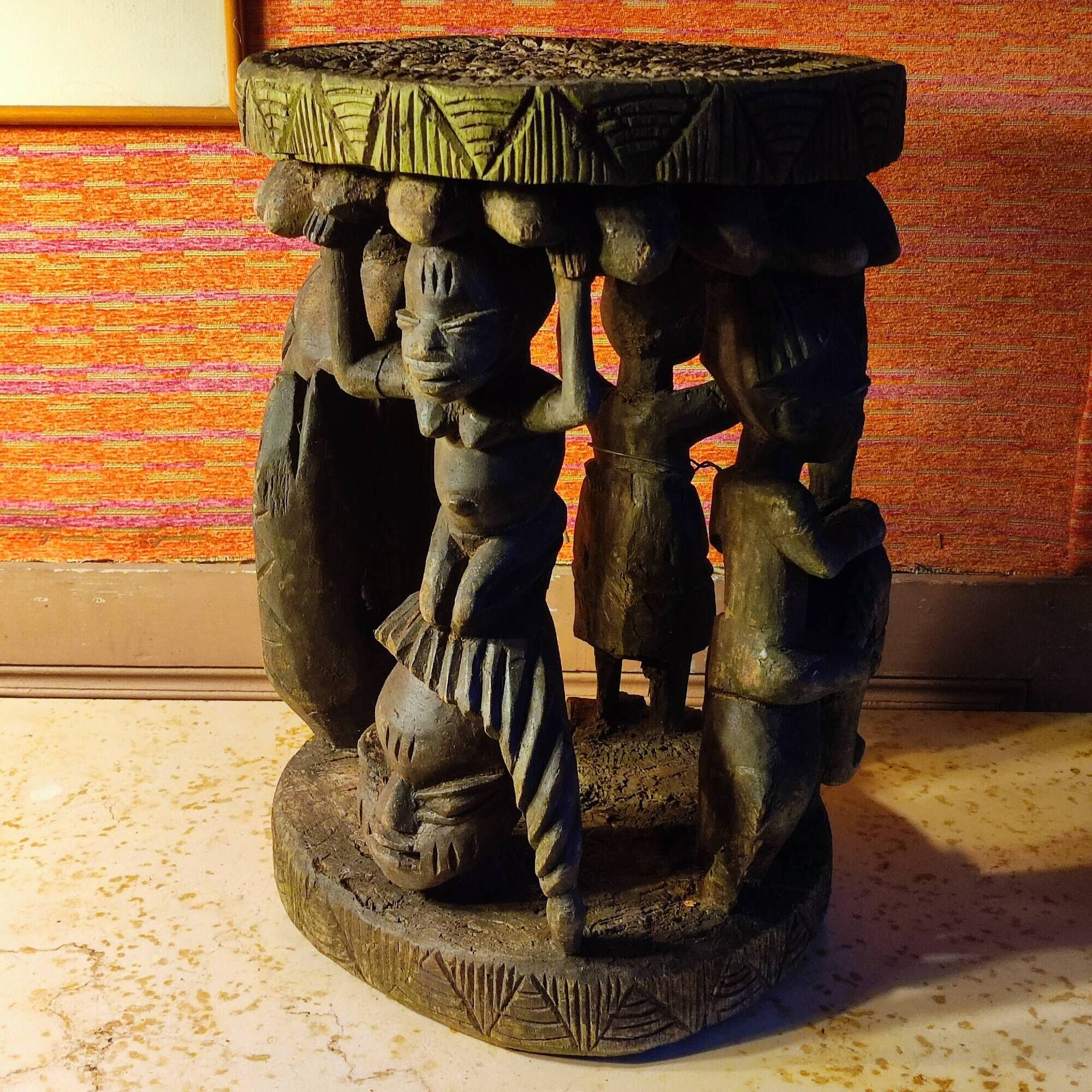 African wooden stool carved in the shapes of characters