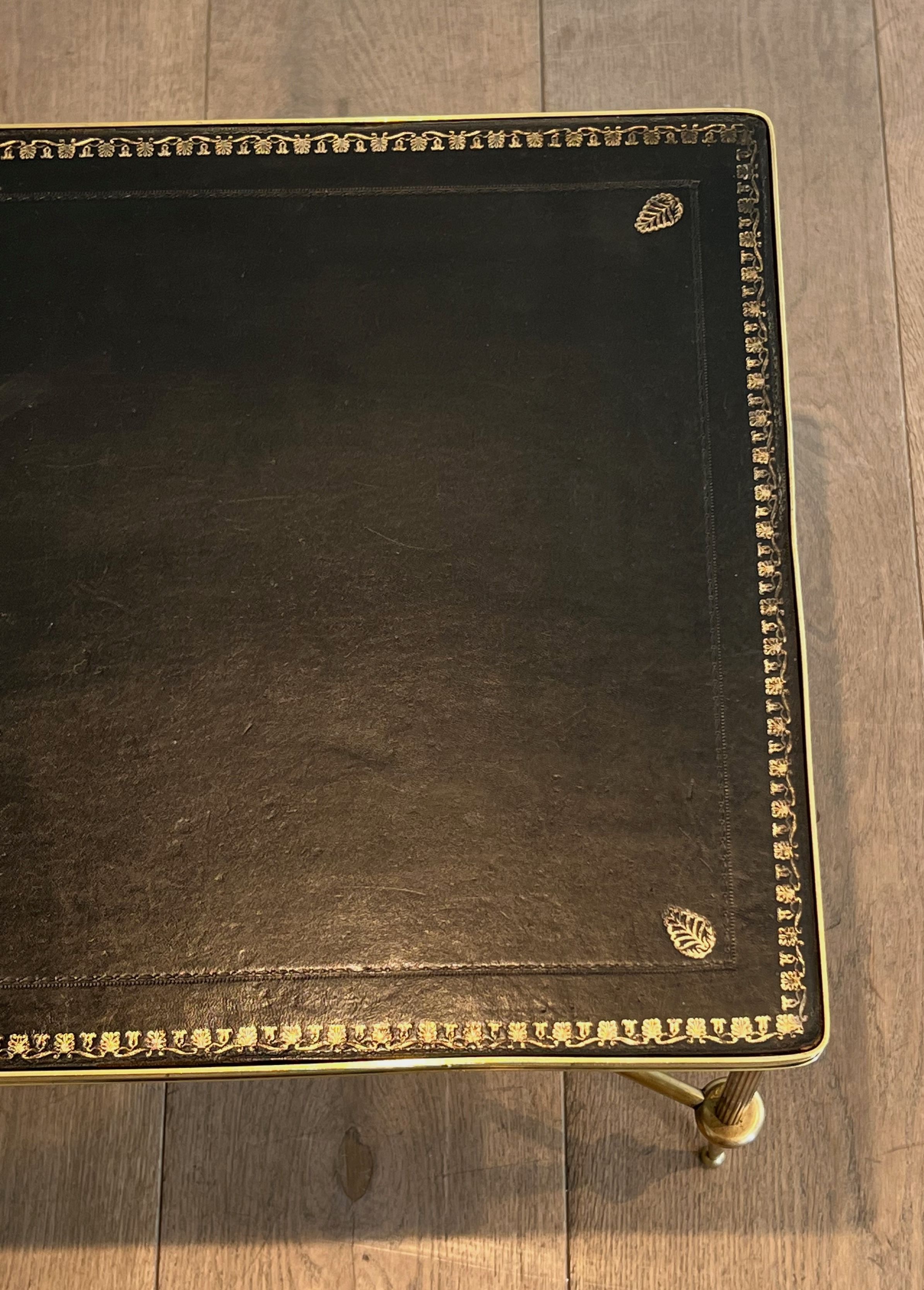 Neoclassical brass coffee table with a black leather top and golden borders from Maison Jansen.