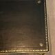 Neoclassical brass coffee table with a black leather top and golden borders from Maison Jansen.