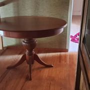 Round solid walnut table with central leg from the 1950s with extensions.