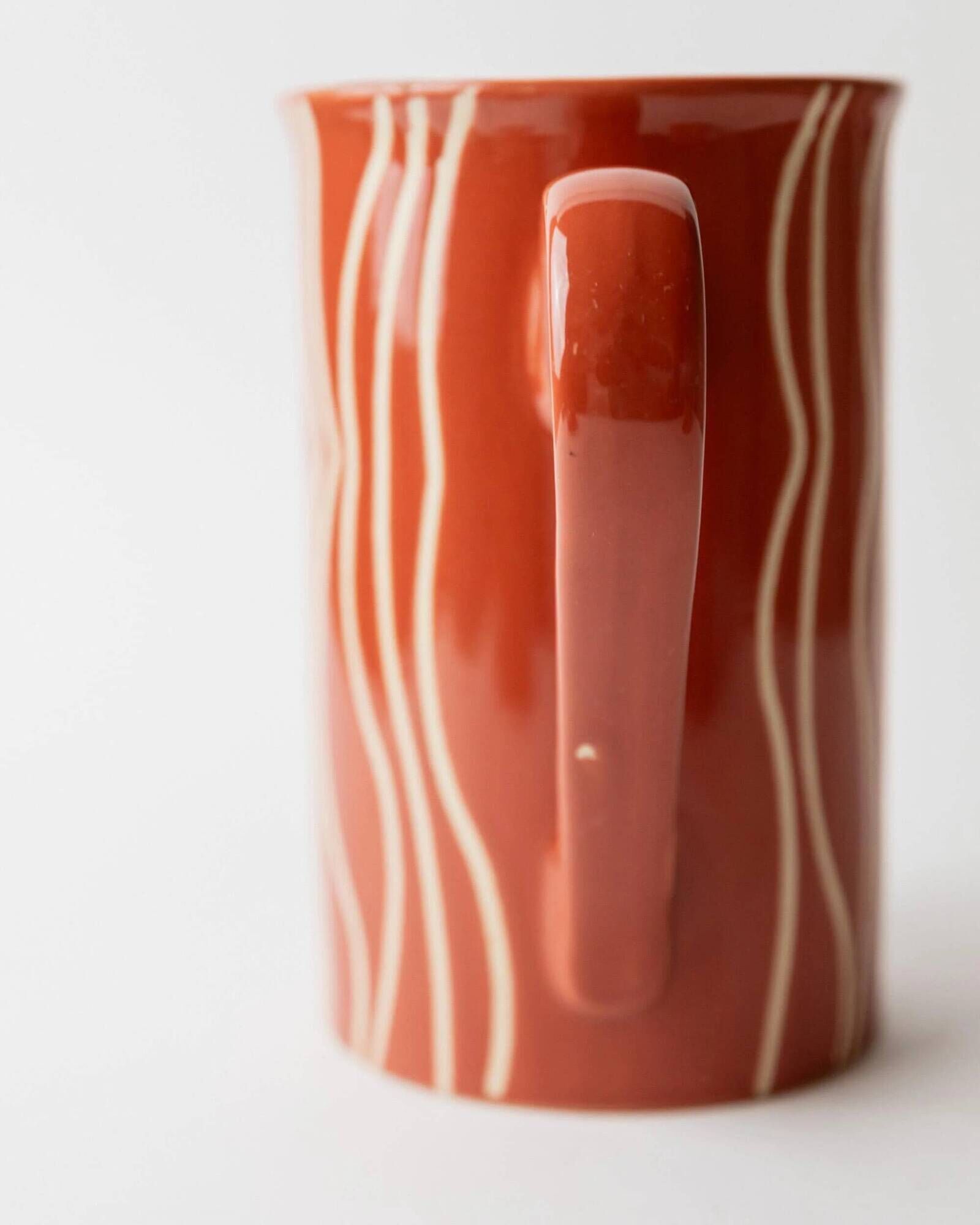 Vintage tea or coffee service in 1970s ceramic, teapot with lid and milk jug, rust orange with retro striped pattern, mid-century decoration, gift idea.