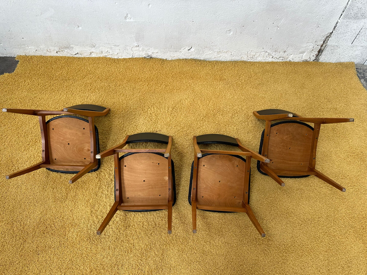 4 Scandinavian chairs in teak and black faux leather.