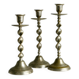 Three metal candle holders, twisted design, patinated finish, vintage style.