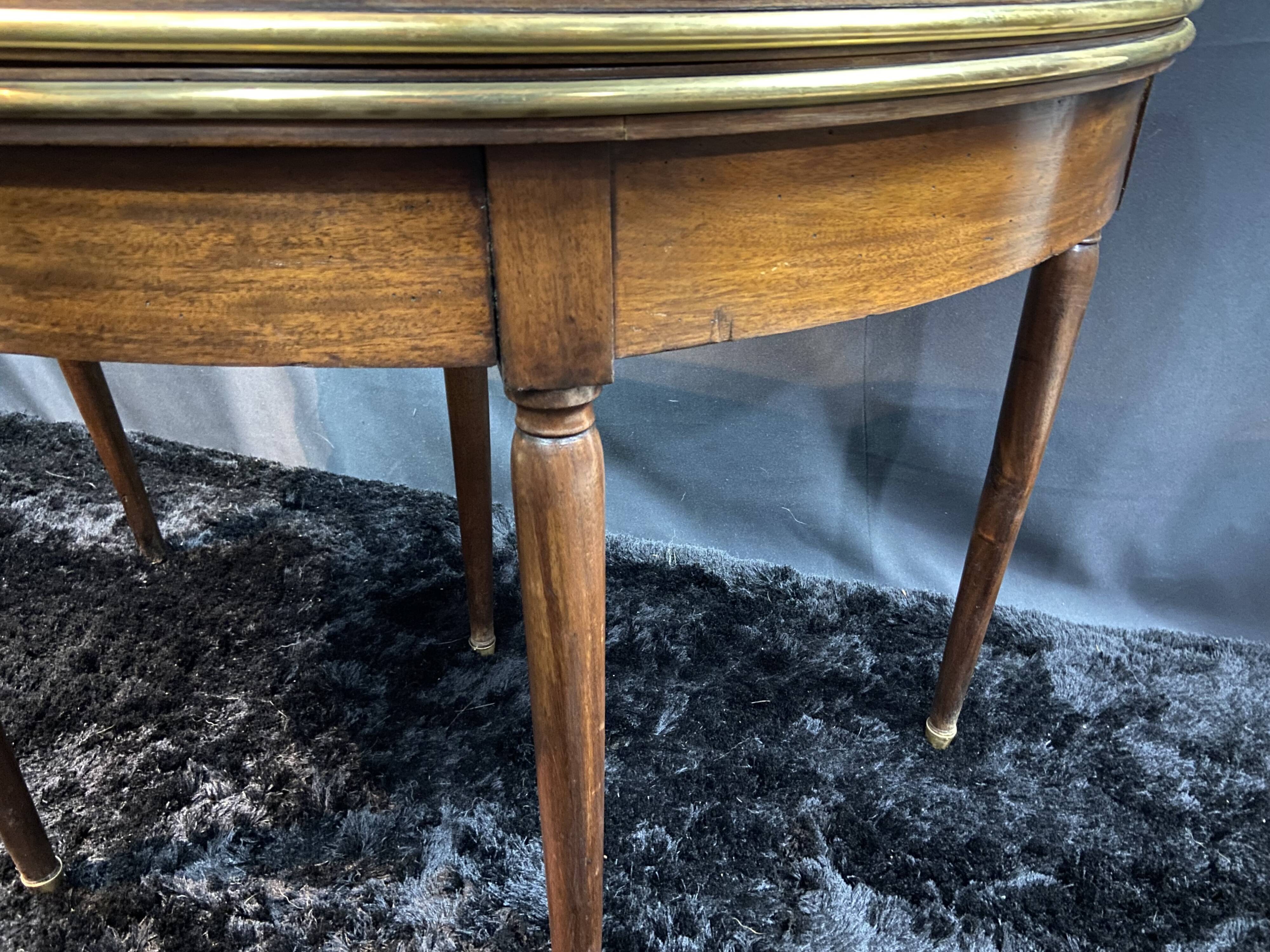 A Louis XVI period mahogany half-moon table forming a console/games table