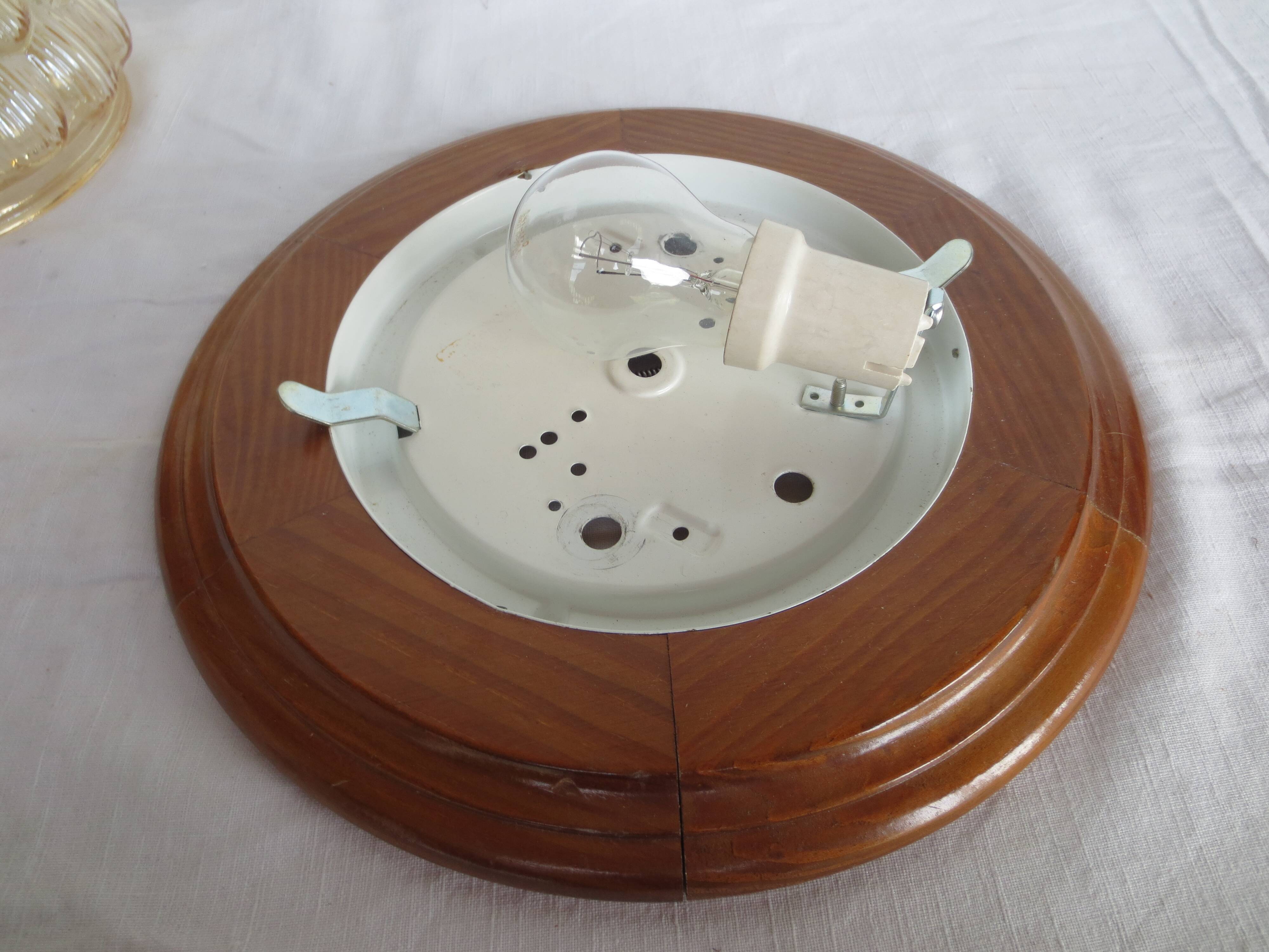 ceiling light with amber glass globe, on a round light wood base