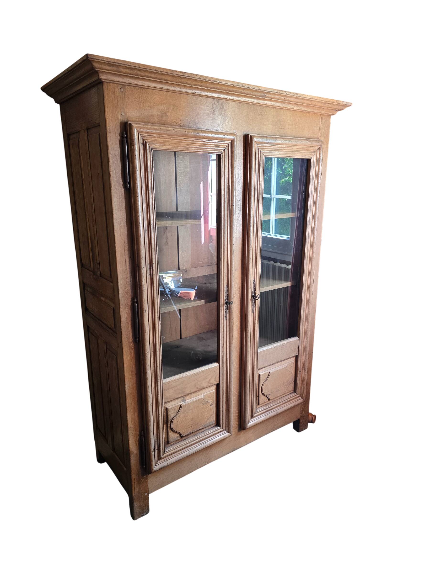 Antique display cabinet in solid oak with two glass doors.