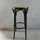 Curved wooden bar stool with a caned seat.