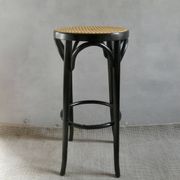 Curved wooden bar stool with a caned seat.