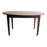Antique wooden folding table with a patina and brass wheels.