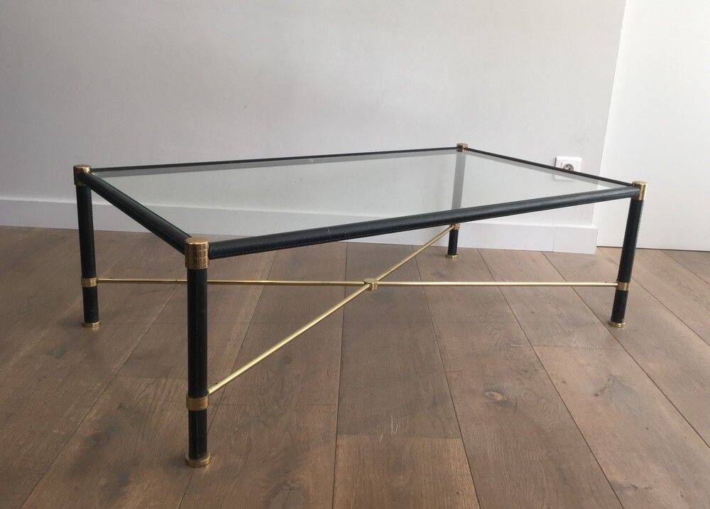Brass coffee table upholstered in black leather. In the style of Jacques Adnet.