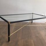 Brass coffee table upholstered in black leather. In the style of Jacques Adnet.