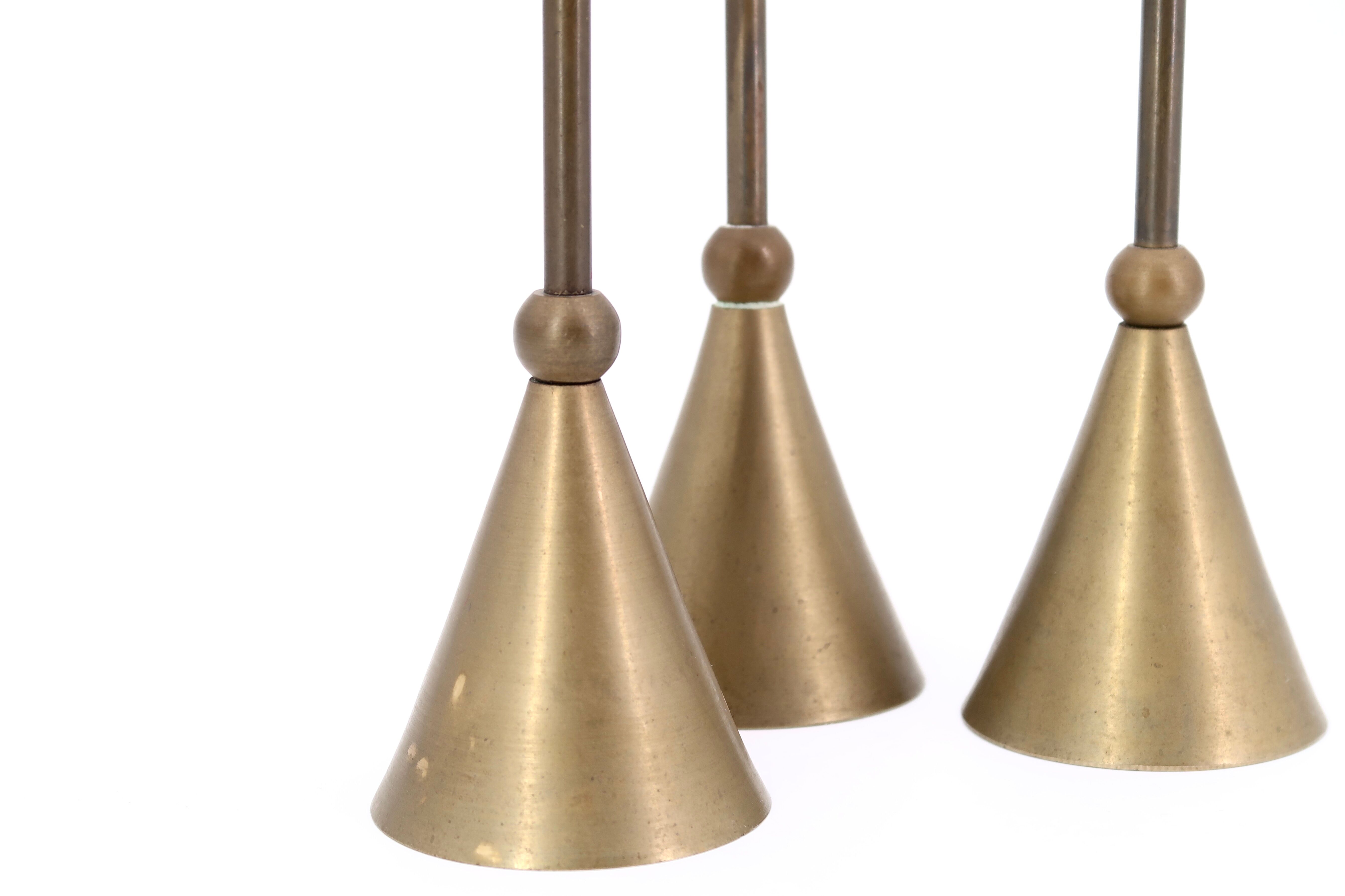 Trio of brass candlesticks by Christian de Beaumont