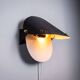 Matte black wall lamps with perforated shades and brass details