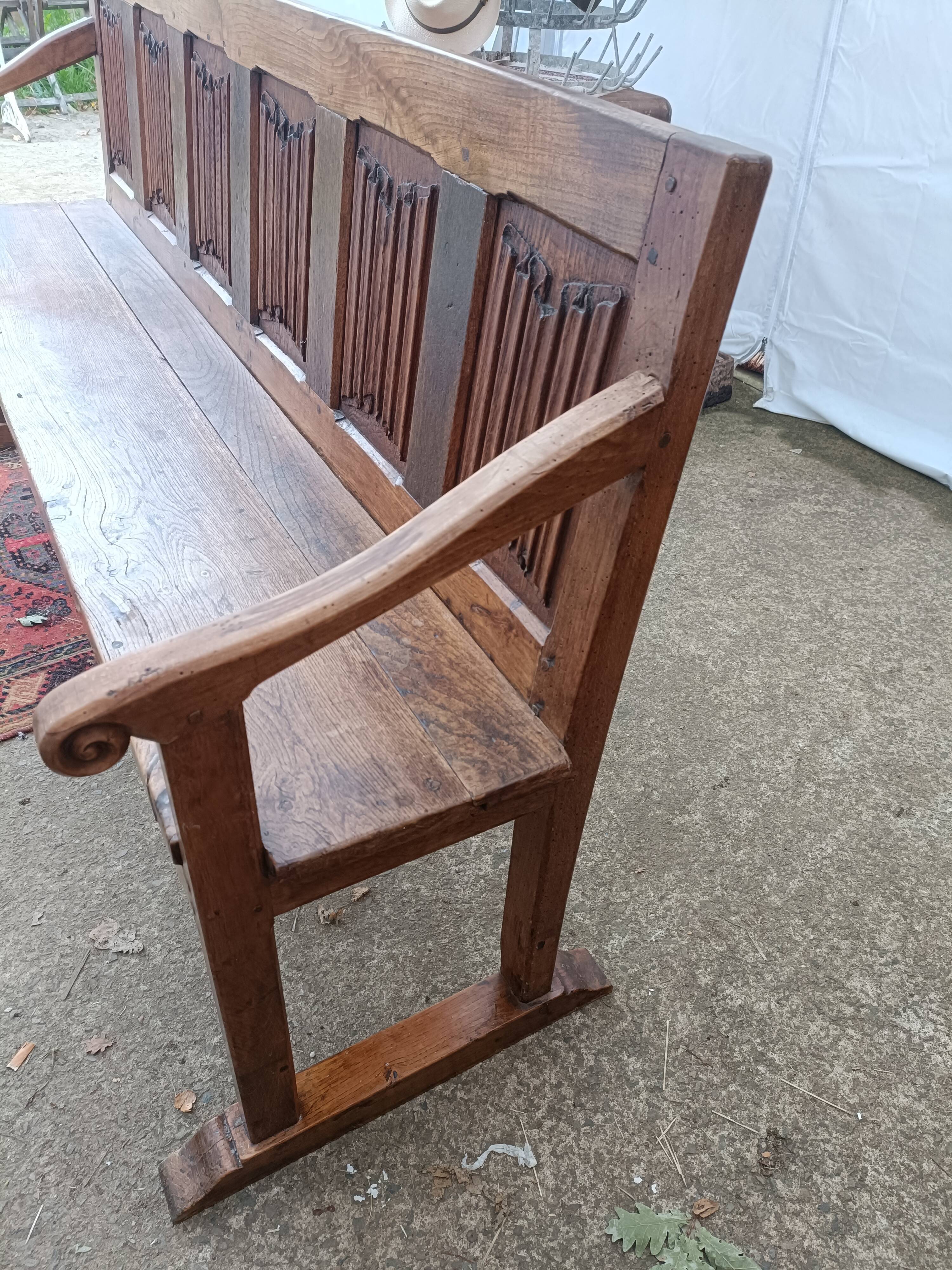 Oak church bench period XVII th century, back decorated with carved parchments