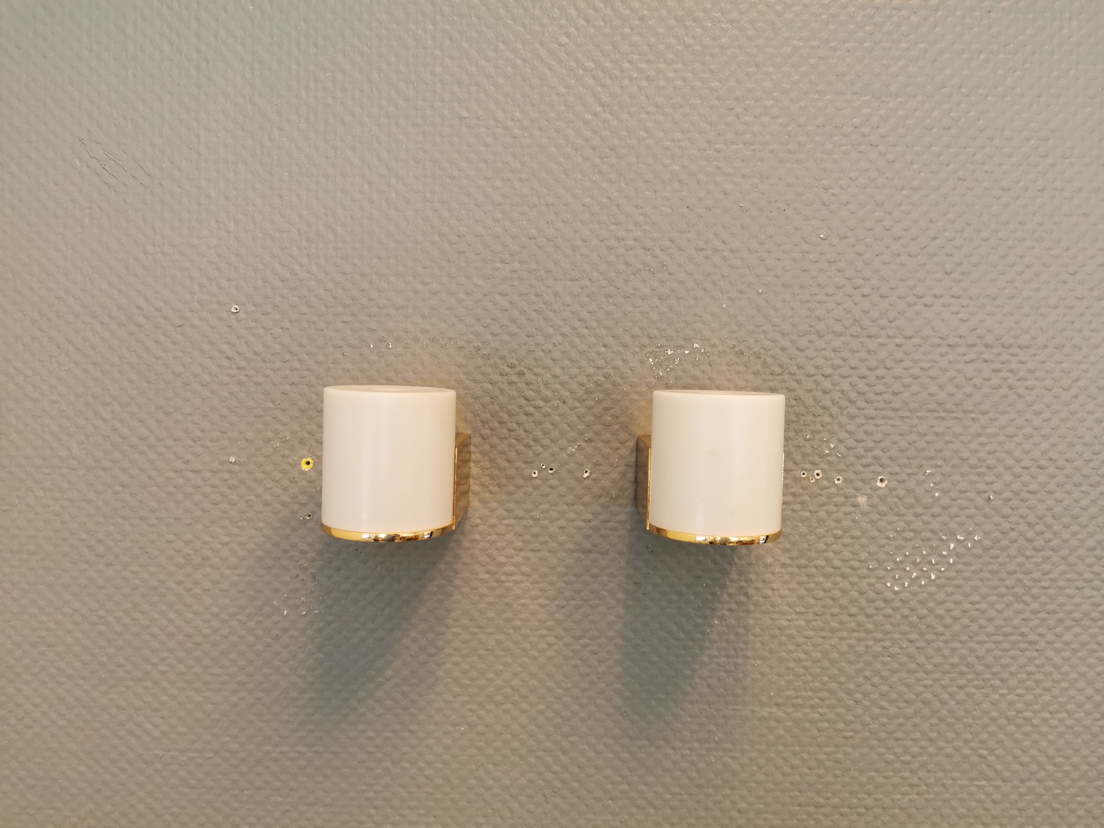Wall lamps with milky white acrylic plastic shades and solid brass bases