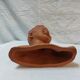 Terracotta bust of a smiling little boy.