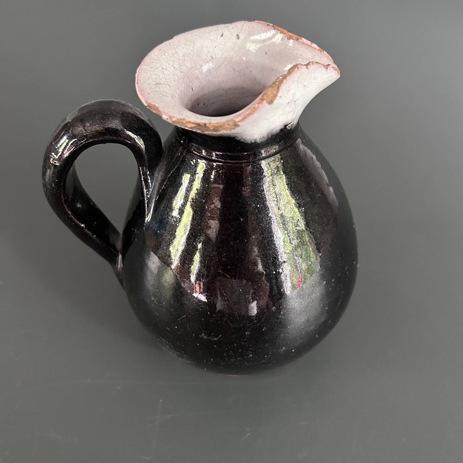 Antique black pitcher with white collar