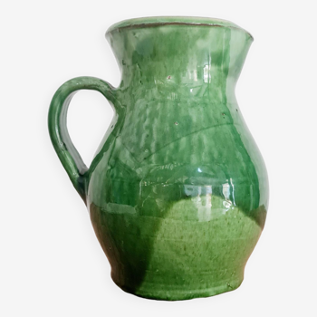 Old green pitcher in painted terracotta