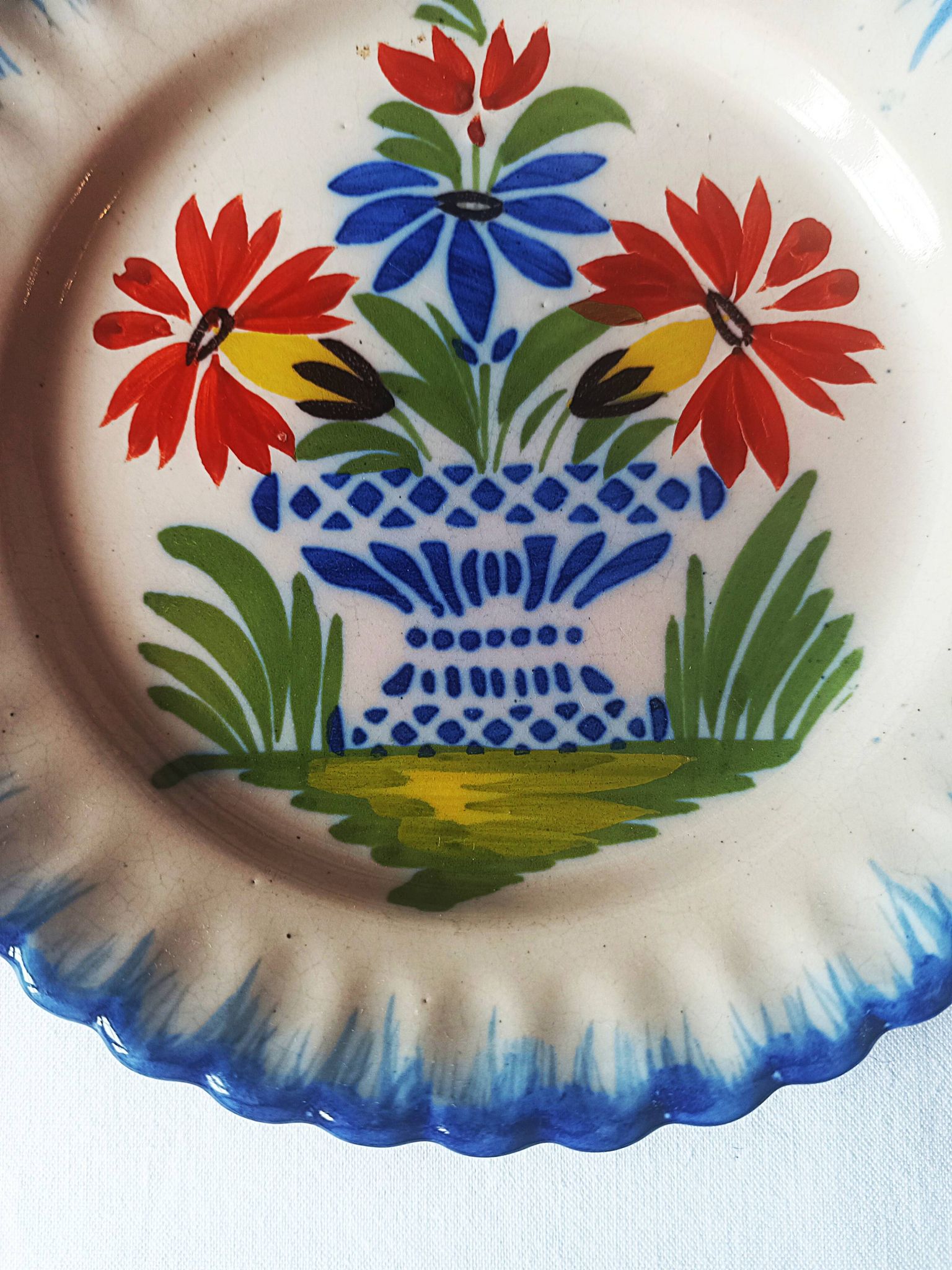 Pair of antique plates in popular earthenware with a floral basket decoration on the edge.