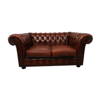 Two-seater brown leather chesterfield sofa