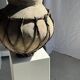 Very large light grey terracotta pot with handles and rattan crossbars.