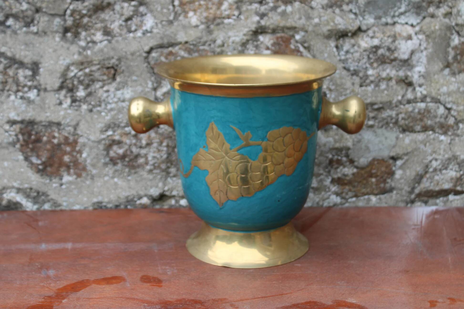 Vintage turquoise brass champagne bucket with grape decoration.