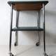 Table serves console with chrome wheels and imitation vintage khaki