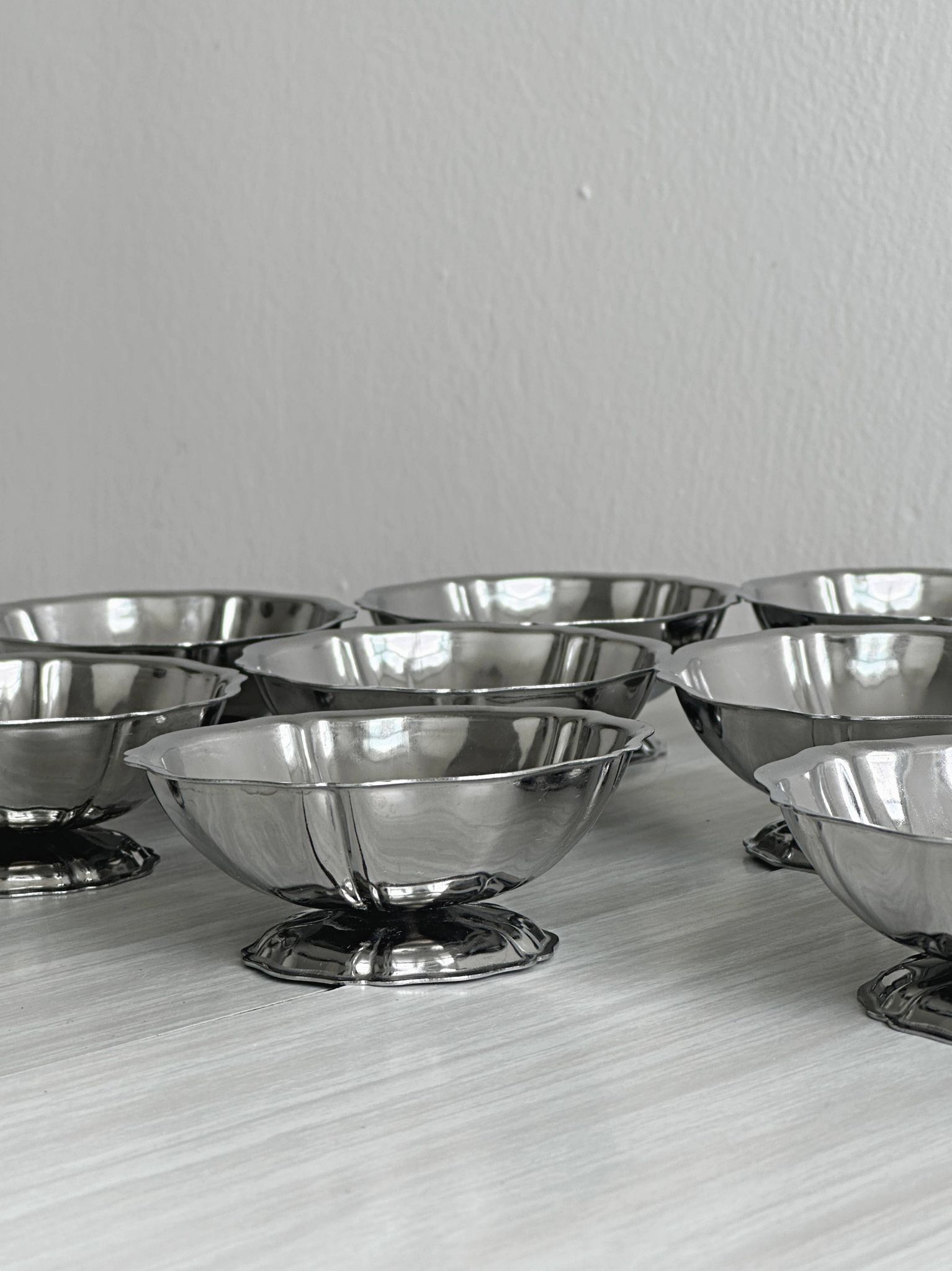 Set of 9 low bowls in shiny stainless steel.