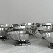 Set of 9 low bowls in shiny stainless steel.