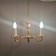 Older brass alloy chandelier with three light sources.