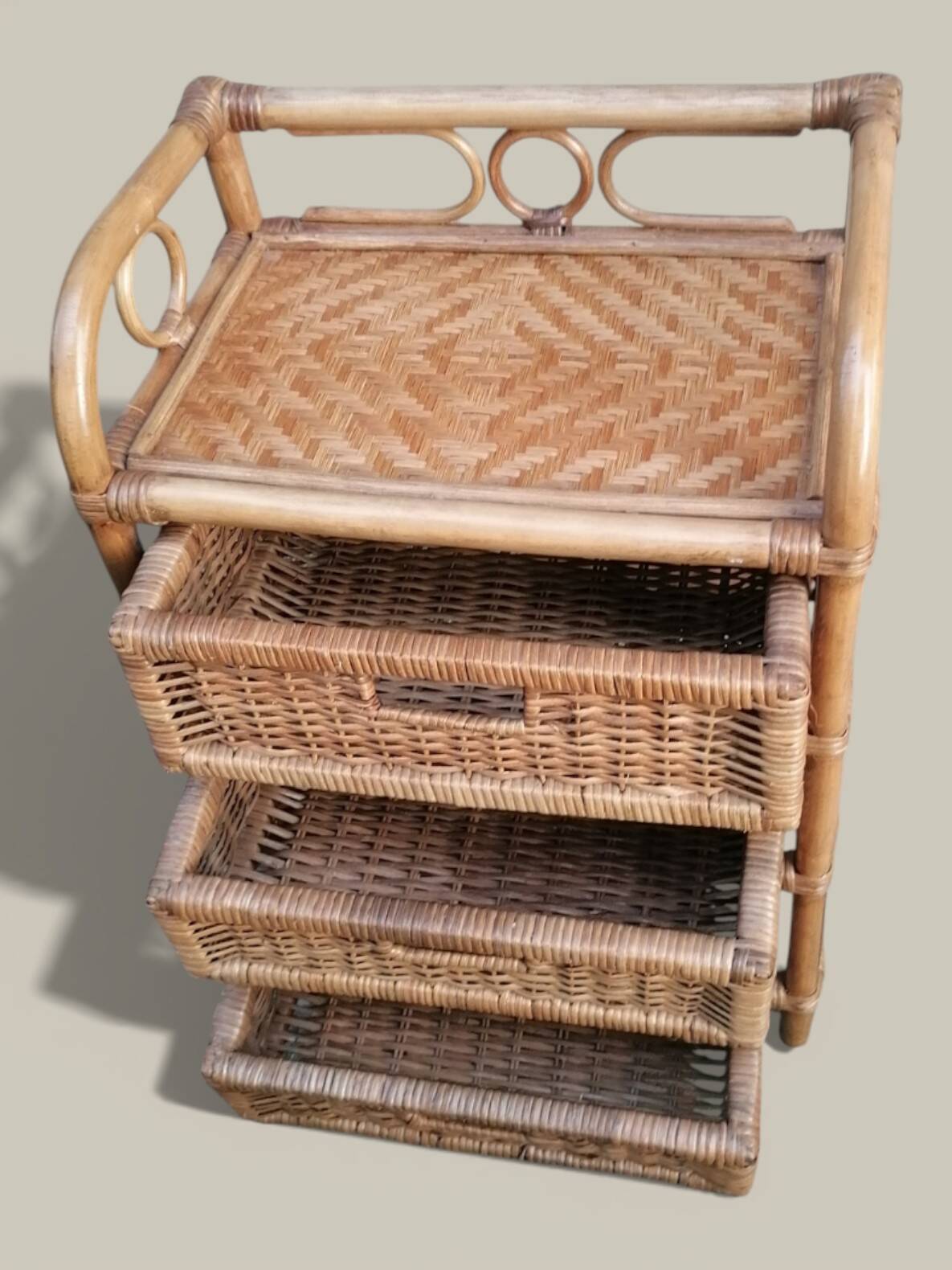 Small storage unit / freestanding shelf in light rattan.