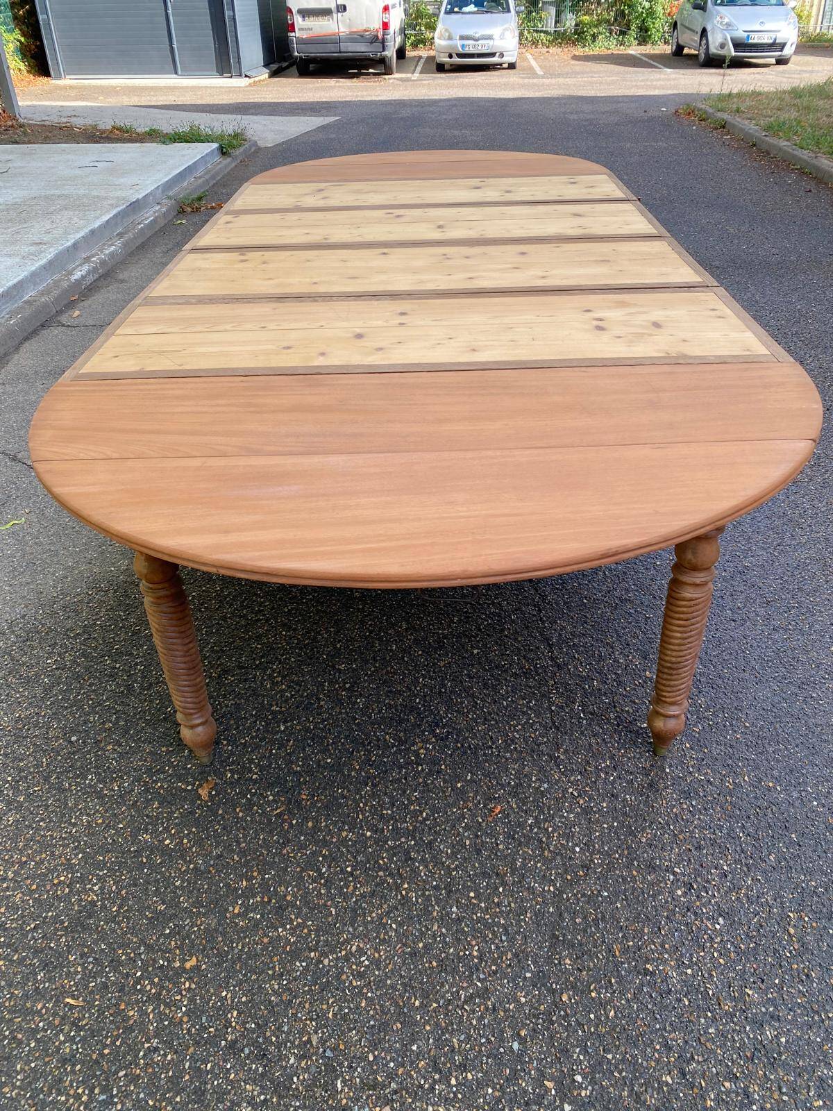 Round extendable banquet table stripped in solid mahogany with 4 extensions, 19th century.