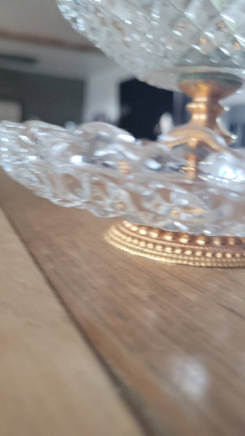 Two-tier display stand in cut glass mounted on a gold metal base.