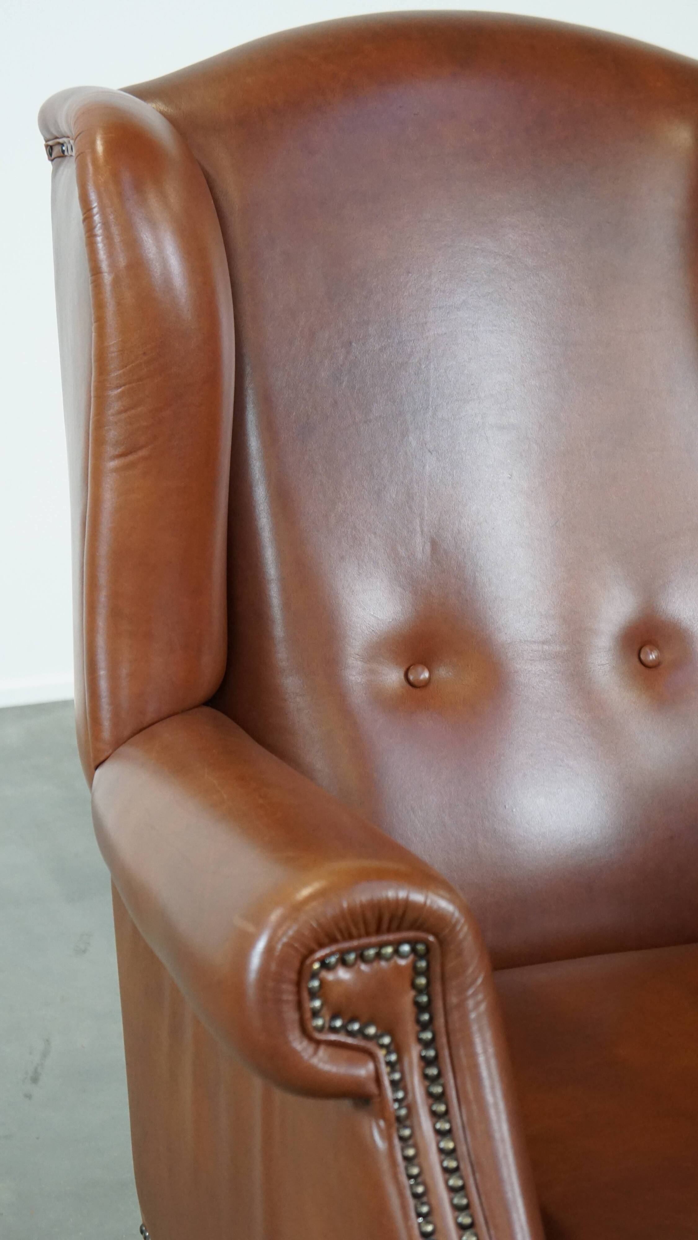 Cognac-colored leather wingback chair in English style