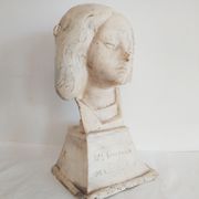 Bust of woman in plaster on pedestal with inscription