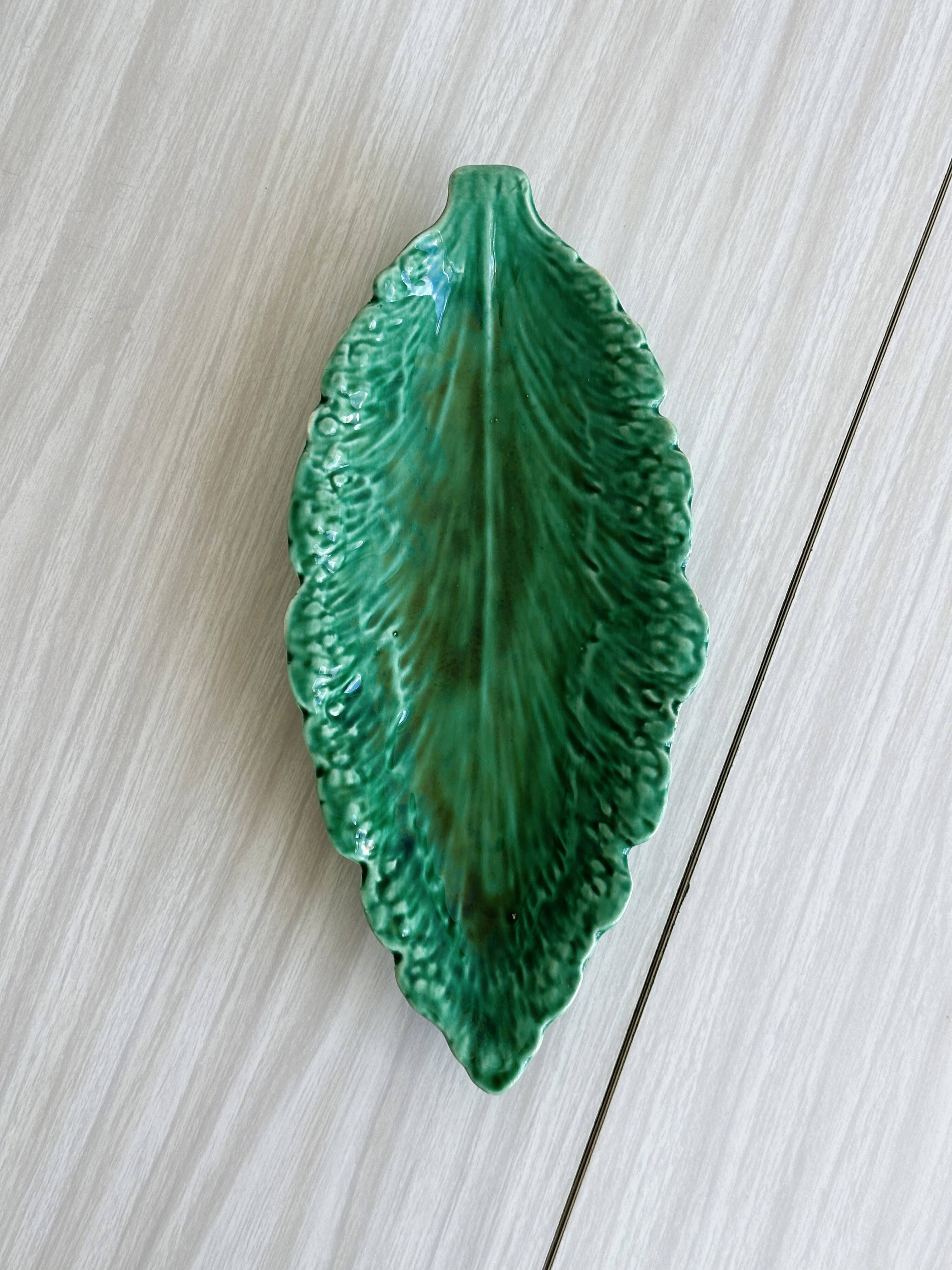 Green earthenware dish in the shape of a leaf
