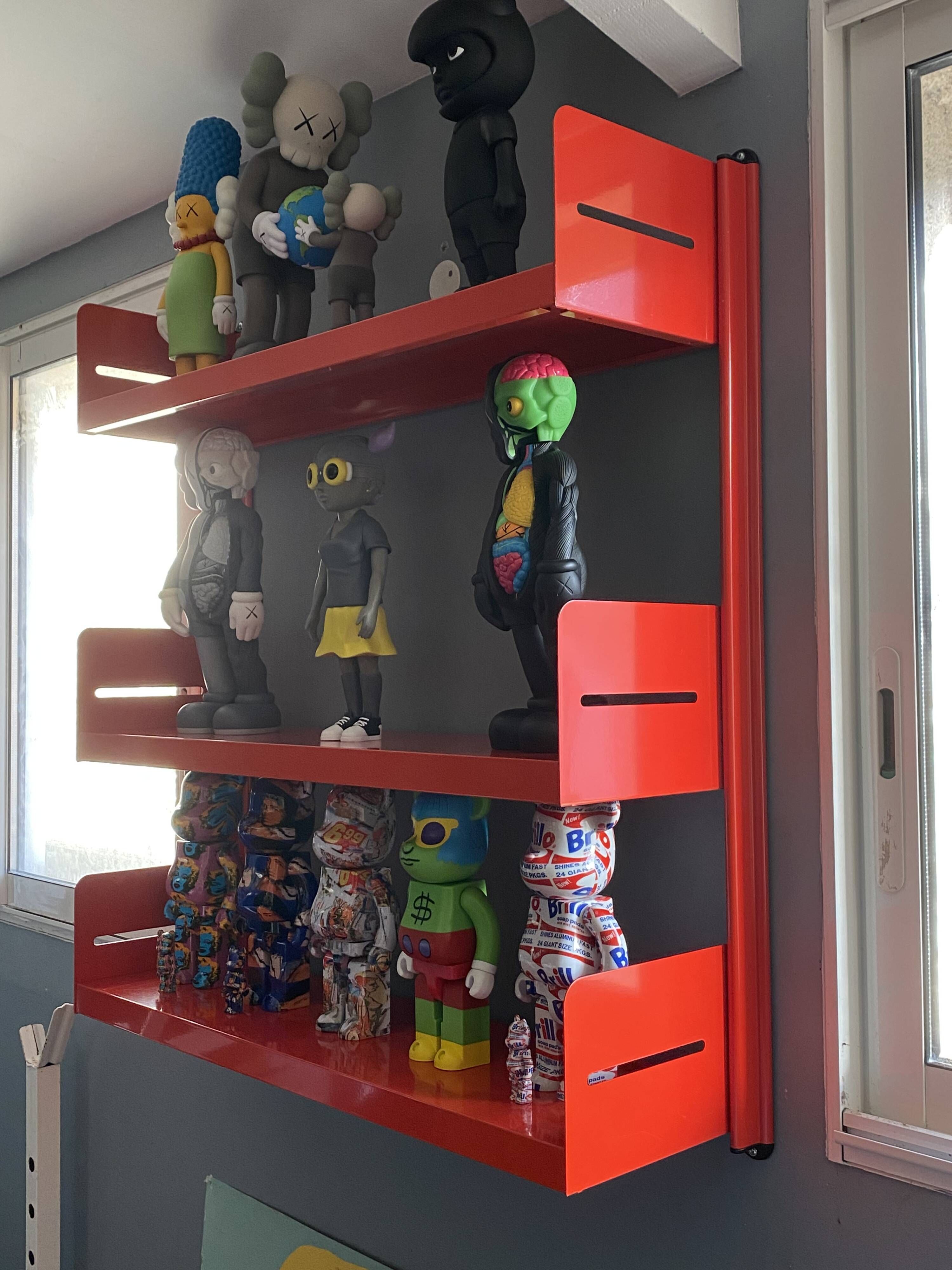 Modular red metal wall shelf in Congresso Lips Vago style.
